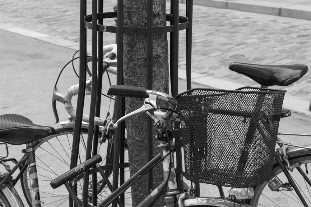 a bicycle parked next to a pole with a basket