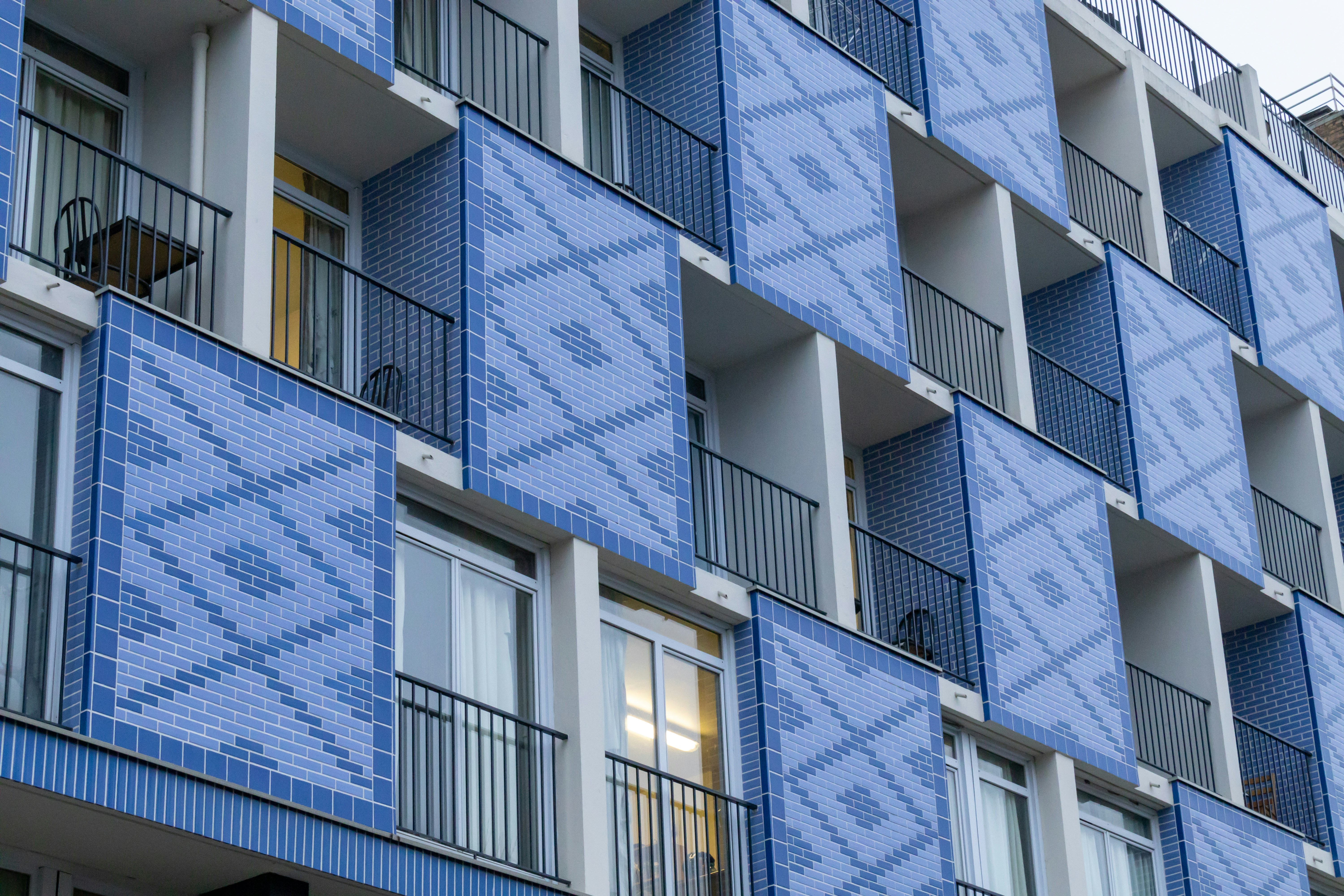a tall blue building with balconies and balconies