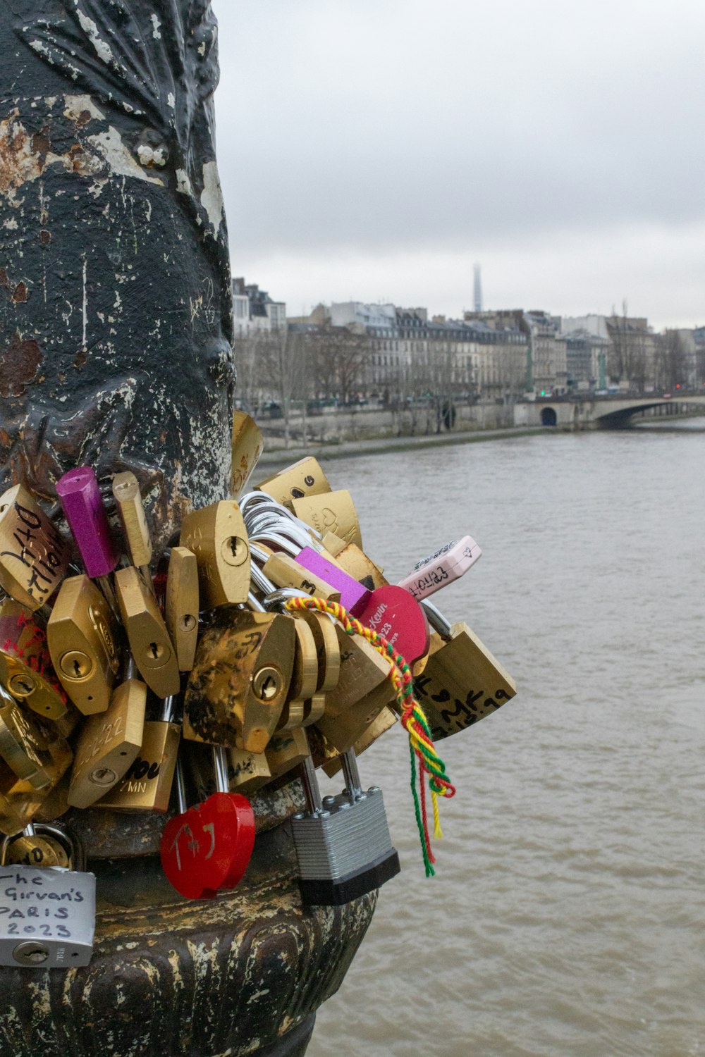 a bunch of locks are attached to a pole