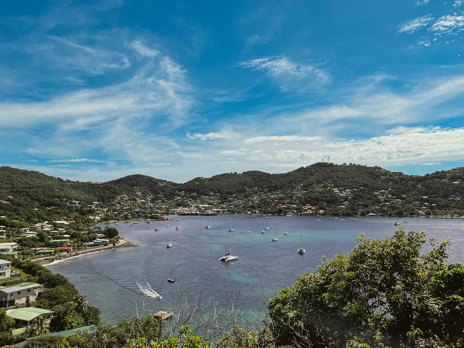 Aerial view of a bay with boats at anchor in Port Elizabeth, Saint Vincent and the Grenadines, calm turquoise water and green hillside, no people visible