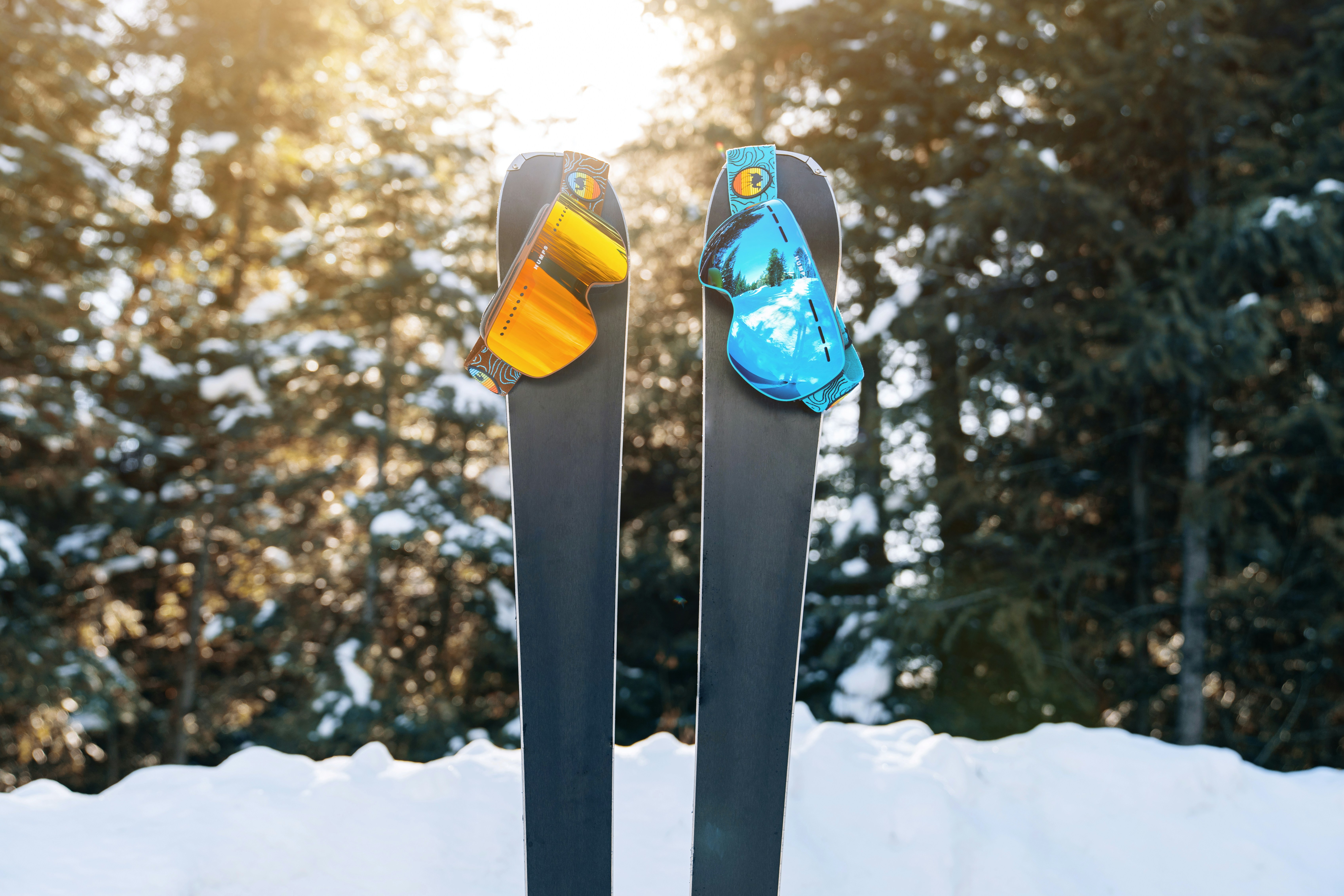a pair of skis sitting on top of snow covered ground, Goggled Up