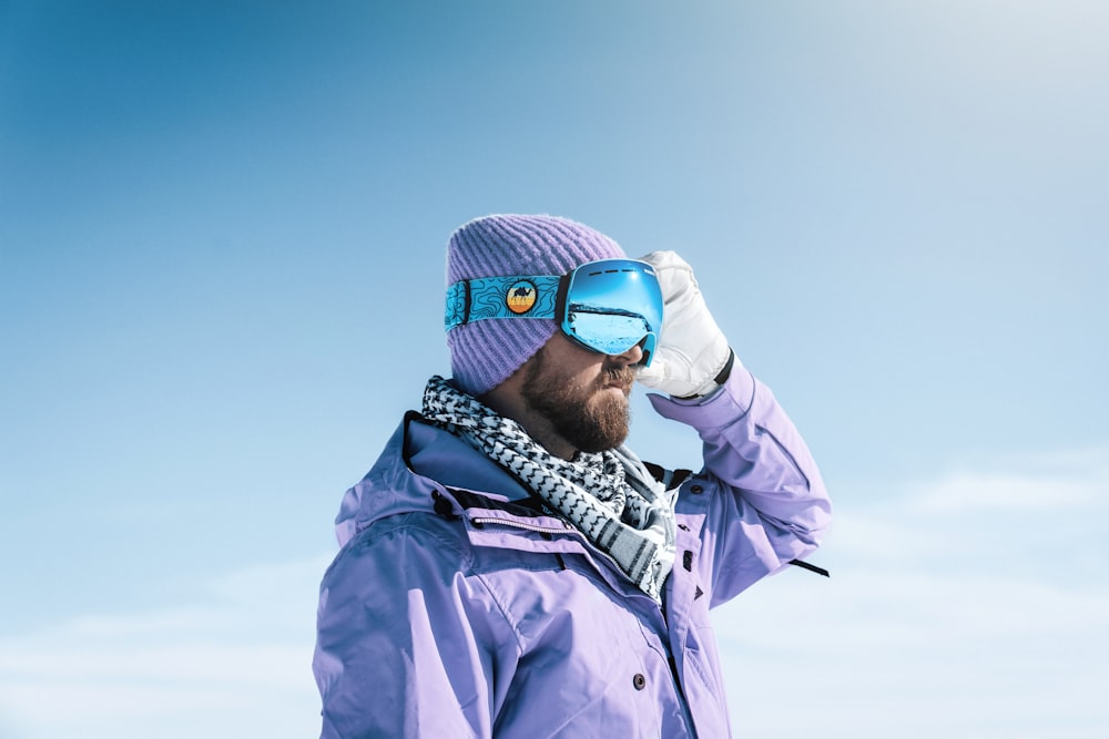 a man wearing a purple jacket and blue goggles