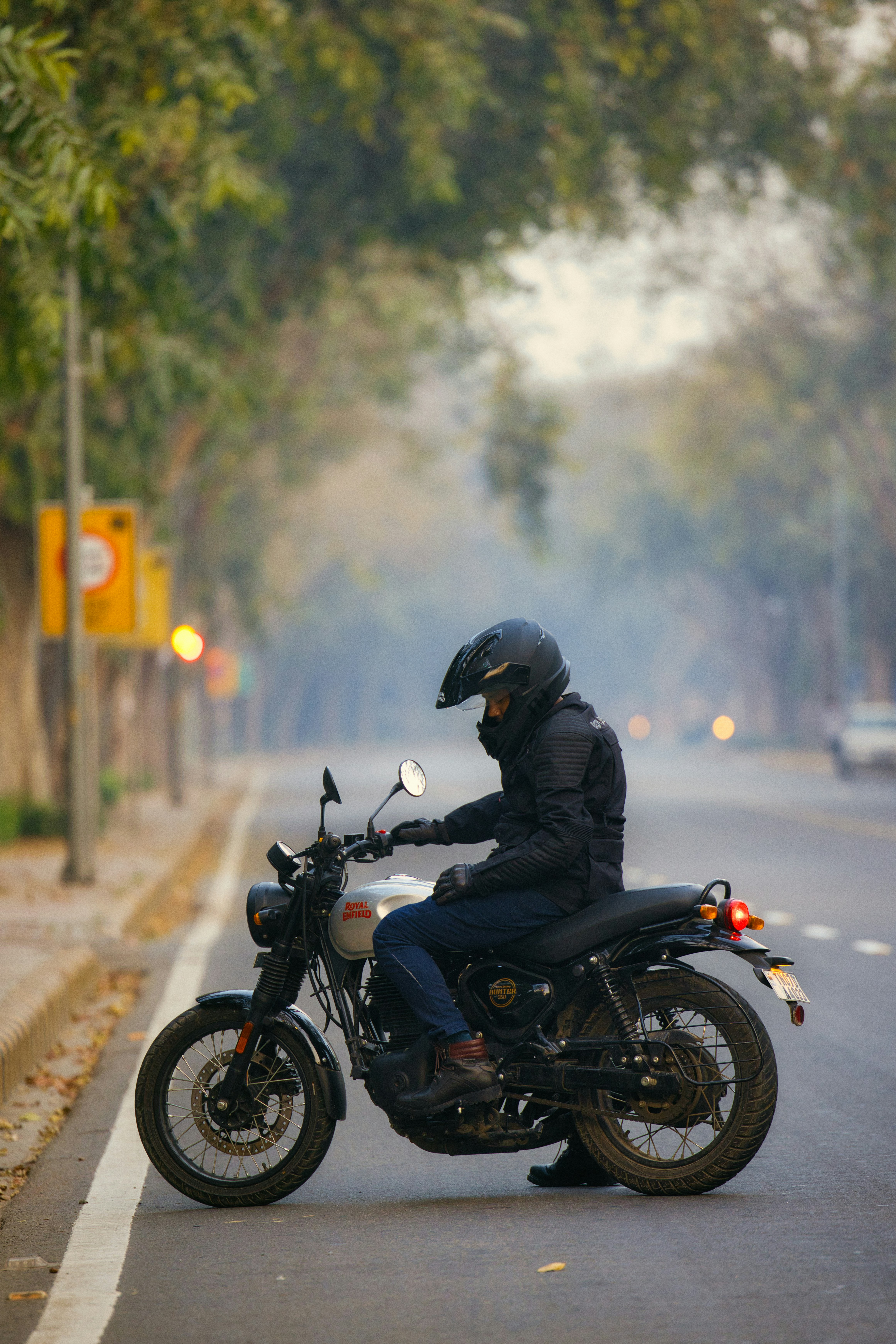 a man riding on the back of a motorcycle down a street
