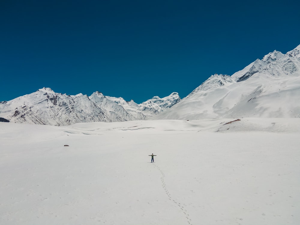 a person on skis in the snow with mountains in the background