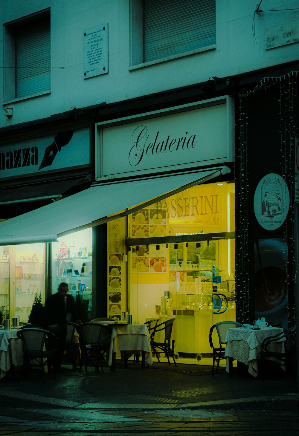 a person sitting at a table outside of a restaurant