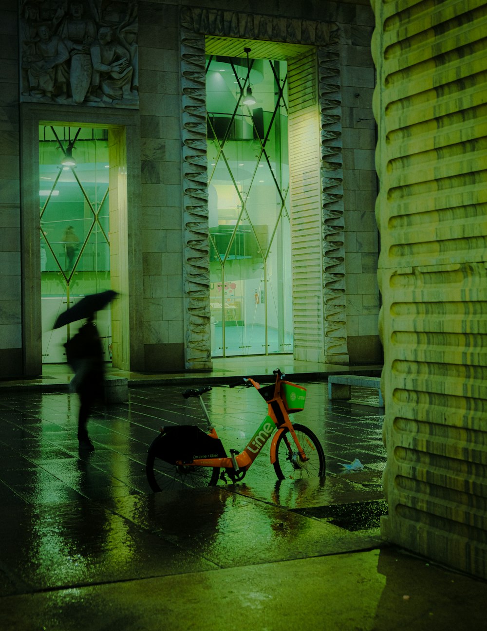 a person walking with an umbrella and a bike in the rain