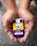 Hands holding a naloxone auto-injector device labeled Evzio, used for opioid emergencies. The device is yellow and purple with instructions for use printed on it.