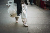 A customer carrying a Myrabag satchel while walking through a bustling city street.