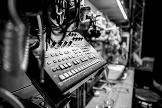 Black and white photo of a music producer working with mixing equipment in a cozy studio.