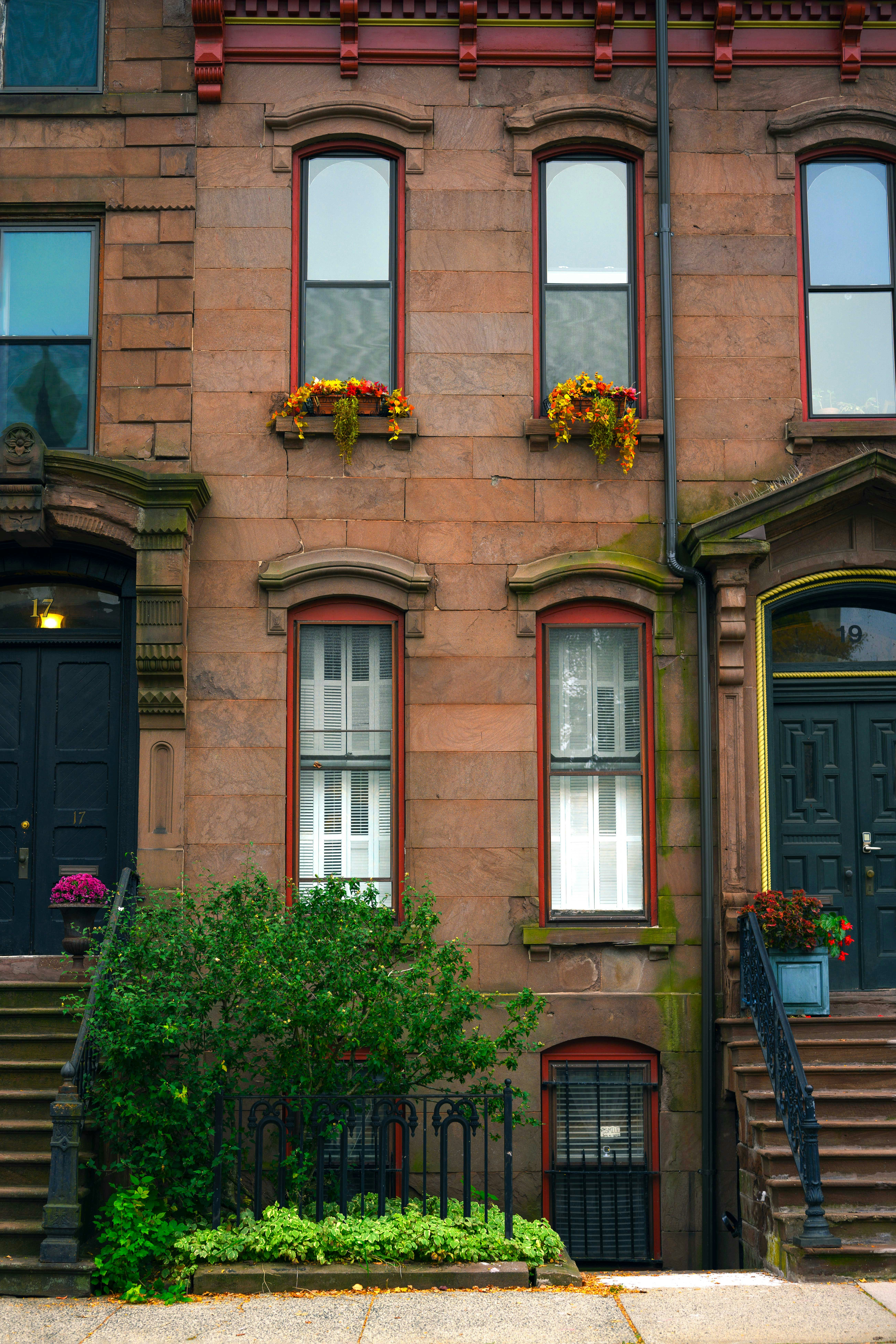 a tall brick building with red trim and windows