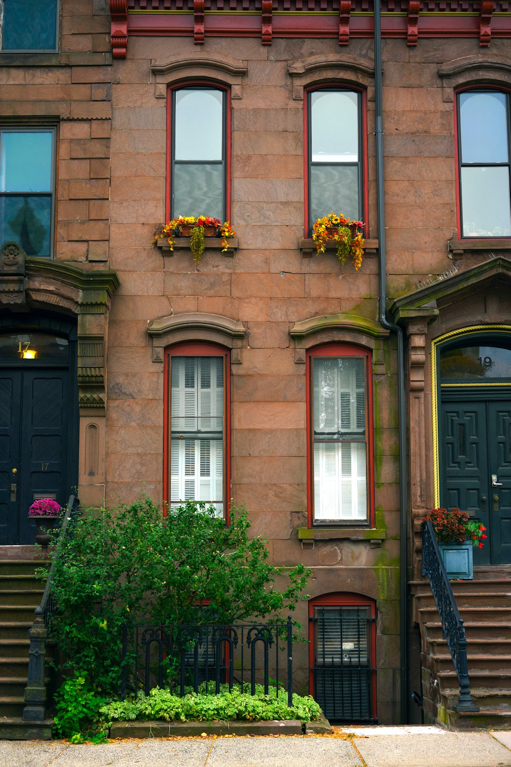 a tall brick building with red trim and windows