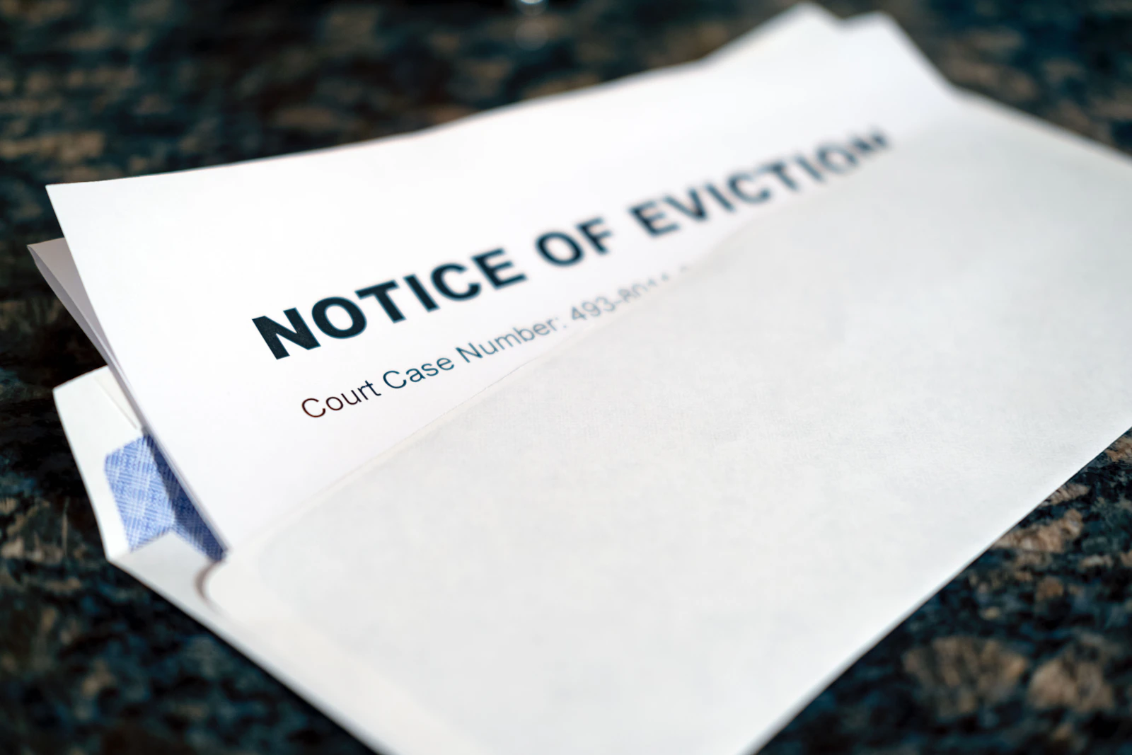 A close-up of a notice of eviction taped to a door