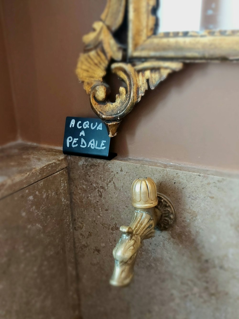 a faucet with a sign on it next to a mirror