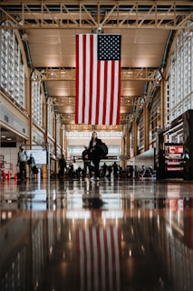 a large american flag hanging from the ceiling of a building