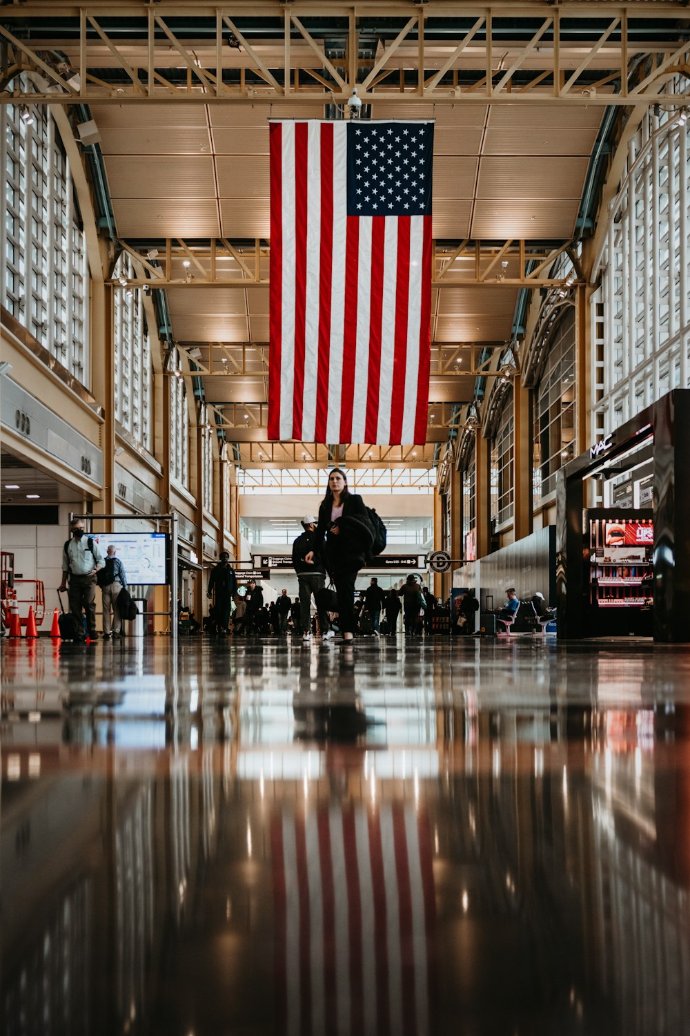 a large american flag hanging from the ceiling of a building