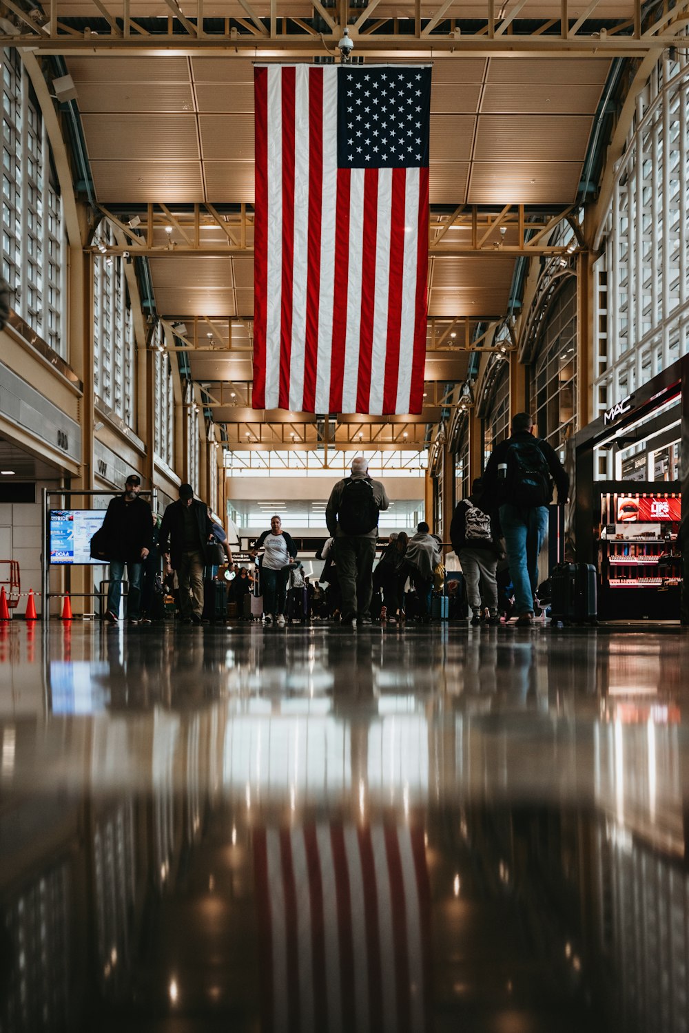 a large american flag hanging from the ceiling of a building