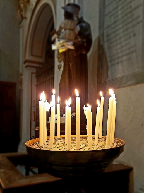 A group of candles lit in a dark room, representing faith and light.