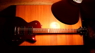 Elegant Fender Telecaster guitar displayed on a wooden stand with warm lighting highlighting its contours.