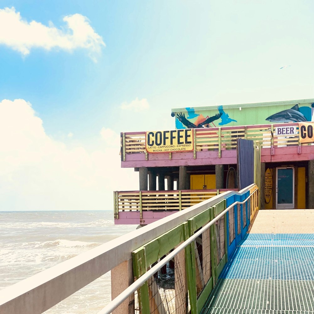 a building with a sign that says coffee next to the ocean