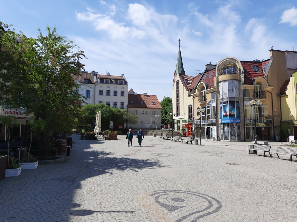 a cobblestone street lined with buildings and trees