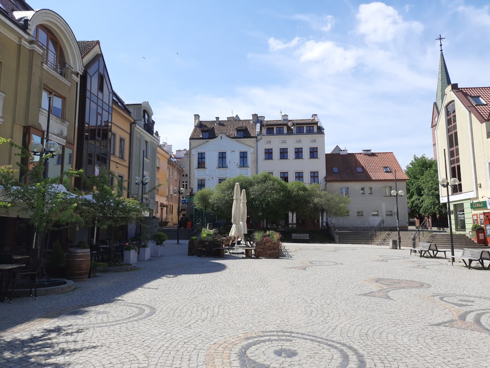 a cobblestone street lined with buildings and tables