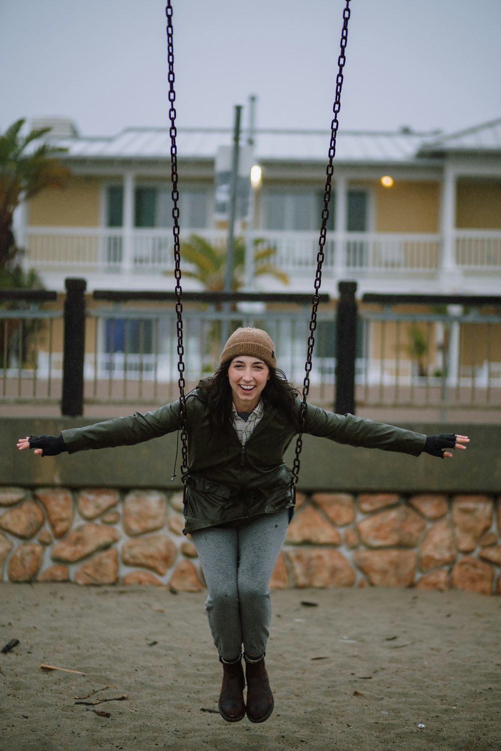 a woman on a swing in front of a building