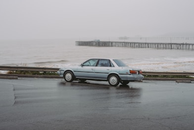 An elegant vintage car parked on a scenic coastal road.