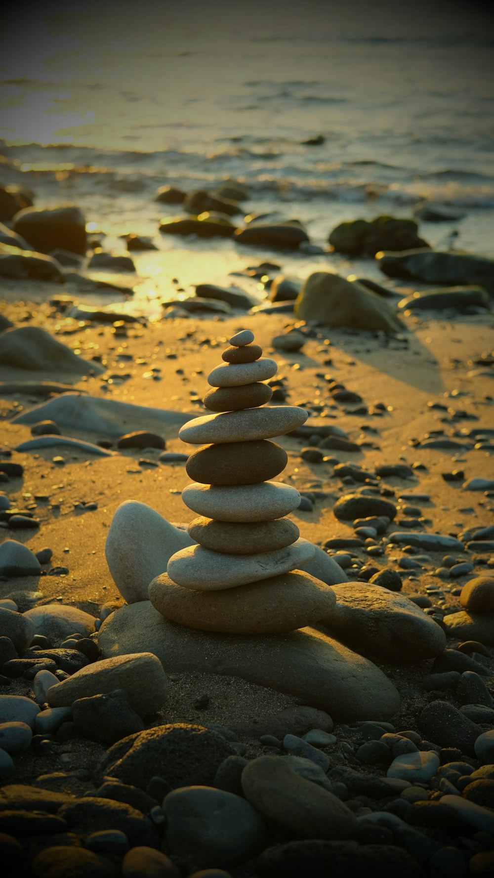 a stack of rocks sitting on top of a sandy beach