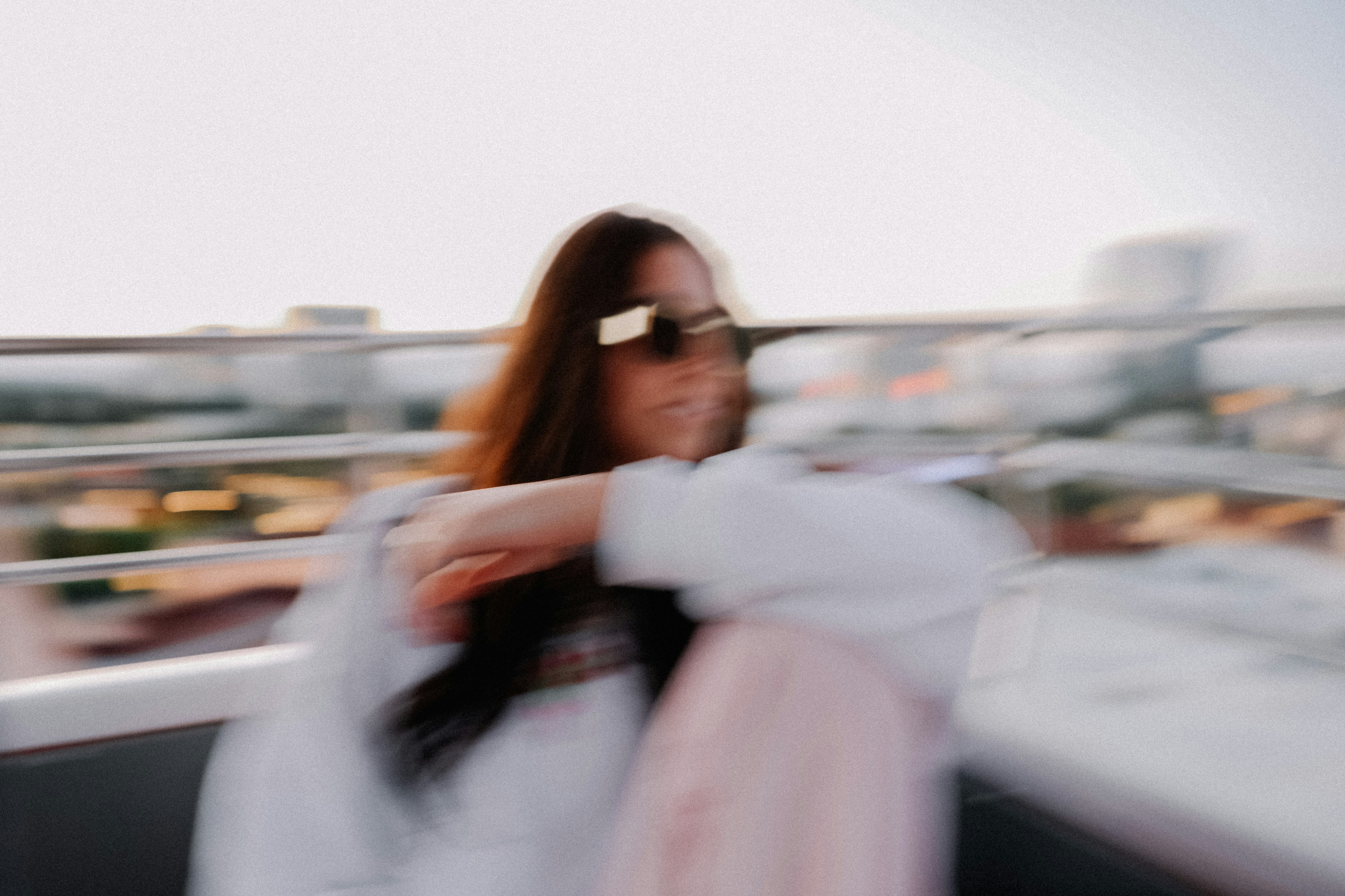 a woman in sunglasses is standing on a balcony