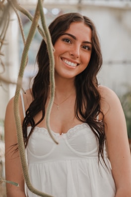Happy young woman standing in her bright, cozy living room with houseplants