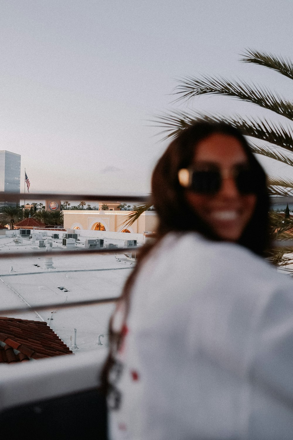 a woman wearing sunglasses standing in front of a window