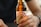 A hand holds a brown glass bottle of Hansa Pilsner beer. The label prominently displays the brand name in red and white colors.