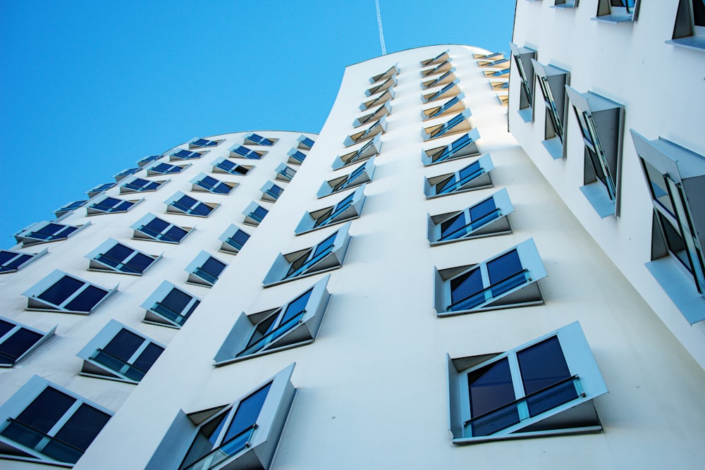 a tall building with many windows and blue sky in the background