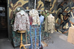 Various military-style clothing and durable accessories displayed on a dark background.