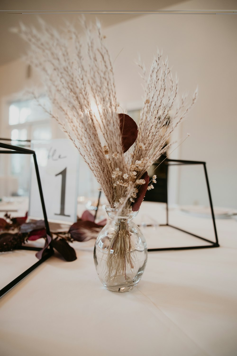 a vase filled with dried flowers on top of a table