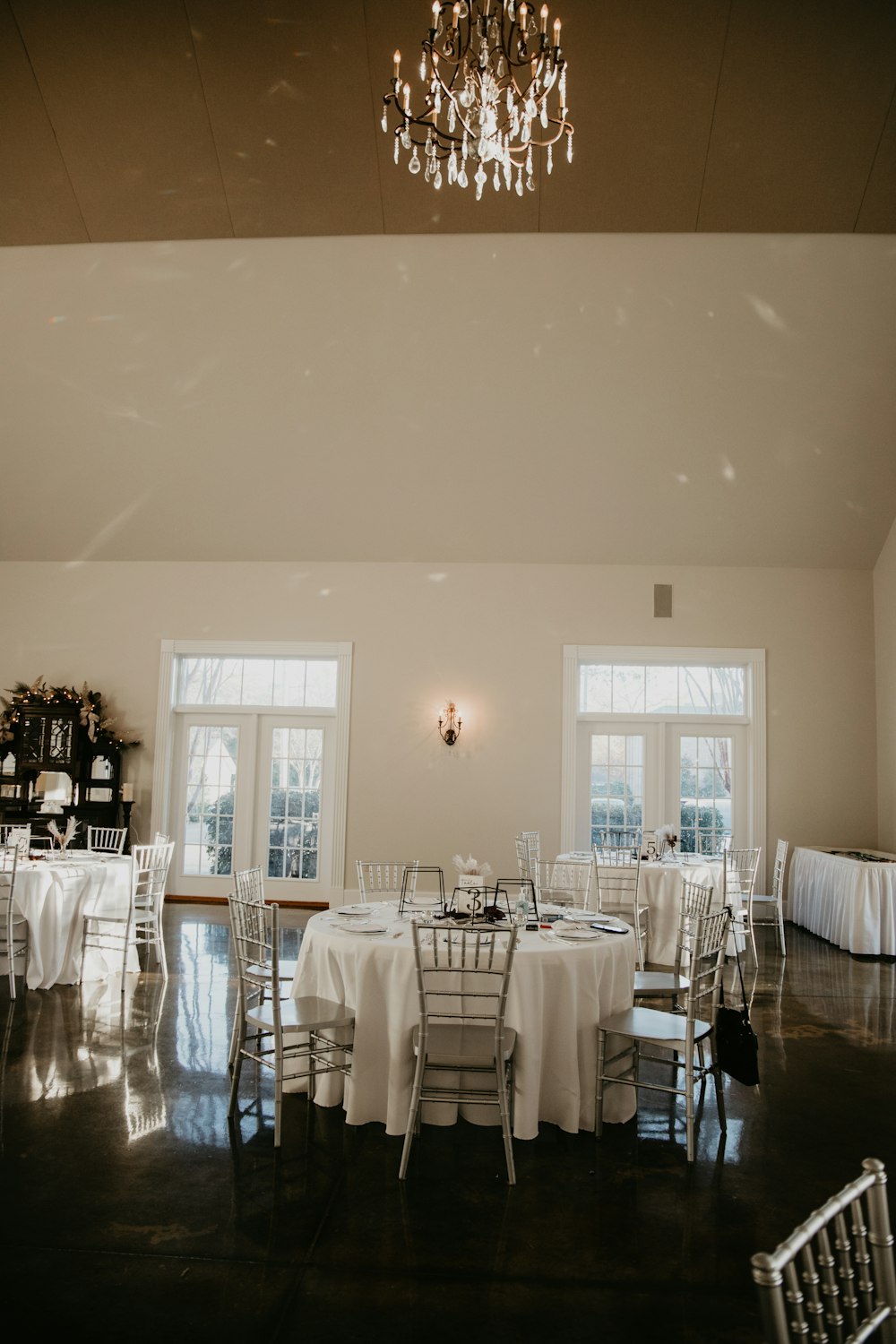 a room filled with tables and chairs covered in white tablecloths