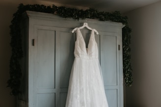 a wedding dress hanging on a door