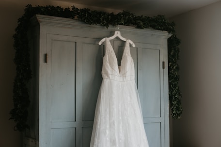 a wedding dress hanging on a door