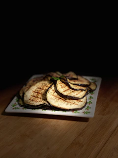 a plate of grilled apples on a wooden table