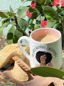 Close-up of a vibrant mug featuring a cheeky, playful quote on a bright background.