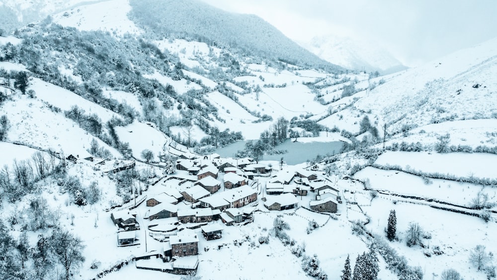 a snow covered village surrounded by trees and mountains