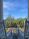 Small wooden porch with a couple of chairs overlooking a peaceful garden