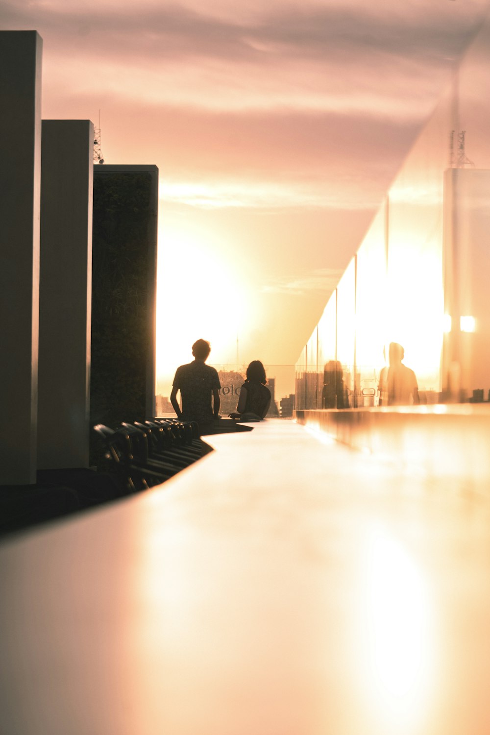 a group of people sitting at a table with a sunset in the background