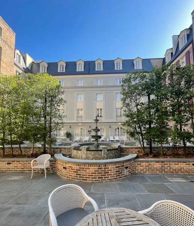 Guests enjoying a peaceful garden courtyard with vibrant flowers and comfortable seating.