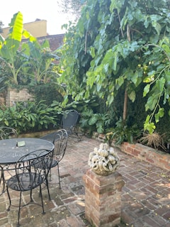 Brick patio with intricate pattern and well-laid joints surrounded by lush landscaping