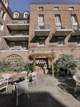 A renovated brick mill building with large windows and new balconies overlooking a quiet courtyard.