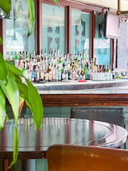Elegant bistro bar counter with rows of colorful cocktails and wine bottles.