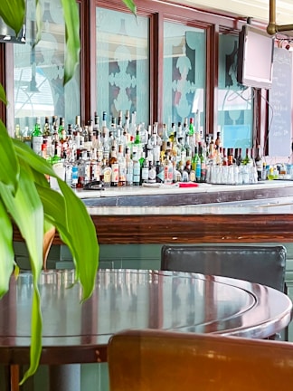 A bar counter with an array of top-shelf bottles and a bartender preparing a drink.