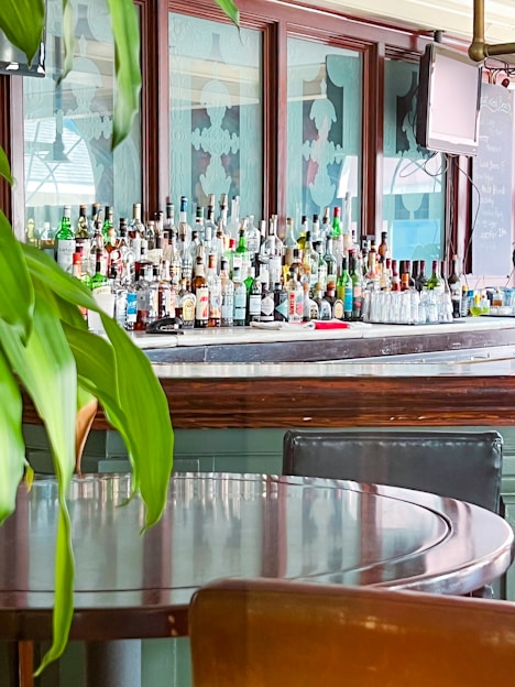 Bottles of artisanal alcoholic beverages displayed on a wooden bar counter