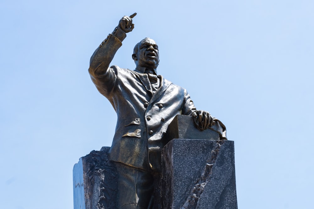 a statue of a man pointing to the sky